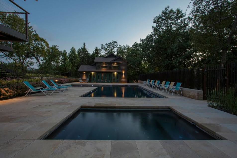 Design ideas for a large transitional backyard rectangular lap pool in Kansas City with a hot tub and natural stone pavers.