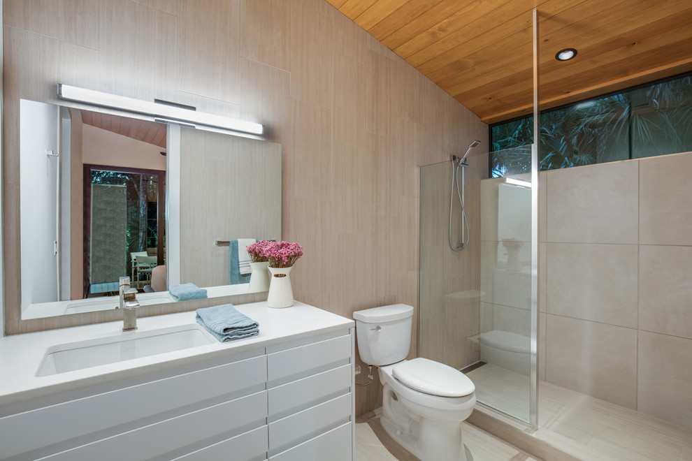 This is an example of a mid-sized contemporary master bathroom in Other with flat-panel cabinets, white cabinets, a two-piece toilet, beige tile, porcelain tile, beige walls, porcelain floors, an undermount sink, beige floor, an open shower, an alcove shower, solid surface benchtops, white benchtops, a single vanity, a built-in vanity and wood.