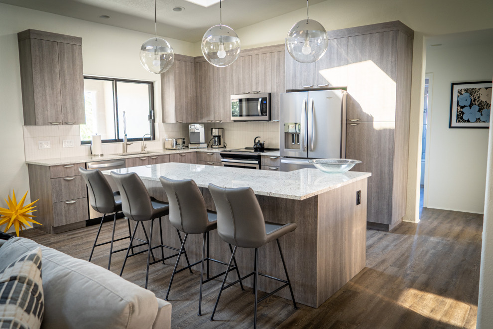 Trendy kitchen photo in Phoenix with flat-panel cabinets, gray cabinets, stainless steel appliances and an island