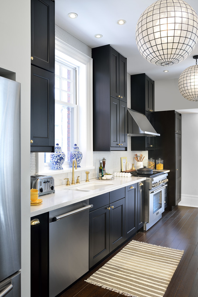 Inspiration for a mid-sized transitional galley kitchen in Toronto with a double-bowl sink, recessed-panel cabinets, black cabinets, quartz benchtops, white splashback, stainless steel appliances, dark hardwood floors and mosaic tile splashback.