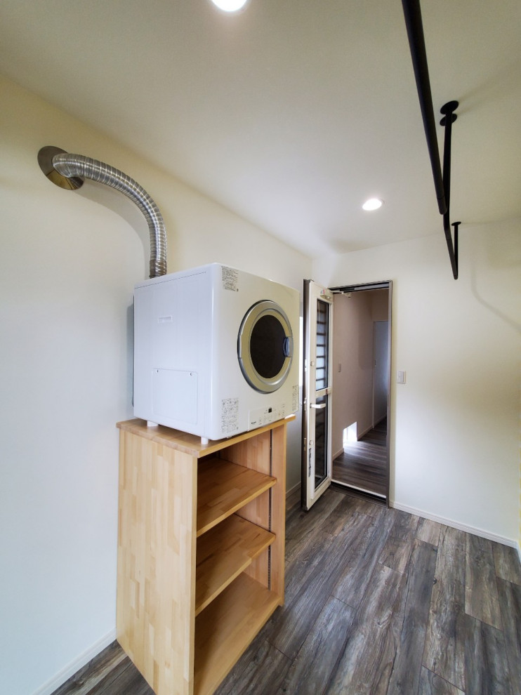 This is an example of a mid-sized arts and crafts dedicated laundry room in Other with yellow walls, painted wood floors, an integrated washer and dryer and grey floor.