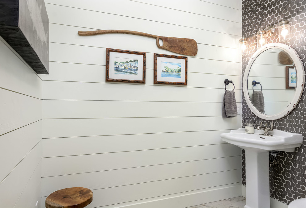Photo of a mid-sized beach style powder room in Orlando with white walls and a pedestal sink.