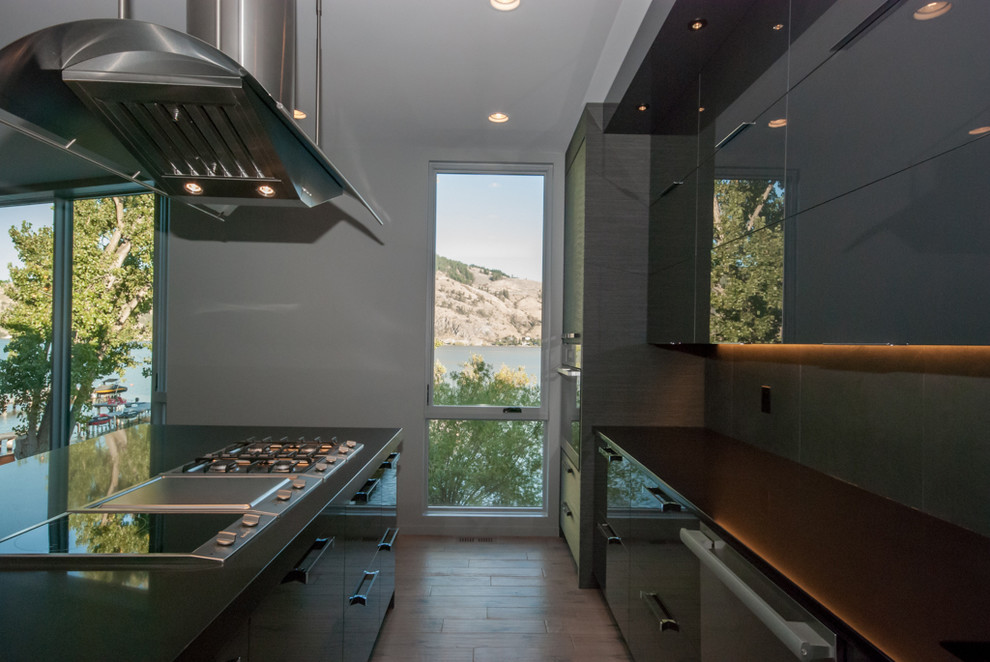 Inspiration for a large modern l-shaped eat-in kitchen in Vancouver with an undermount sink, flat-panel cabinets, quartz benchtops, grey splashback, ceramic splashback, stainless steel appliances, light hardwood floors, with island and grey cabinets.