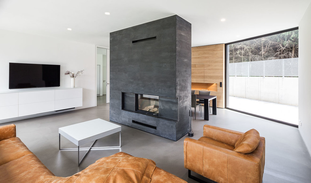 Inspiration for a large contemporary open concept family room in Cologne with white walls, a two-sided fireplace, a plaster fireplace surround, a wall-mounted tv and concrete floors.