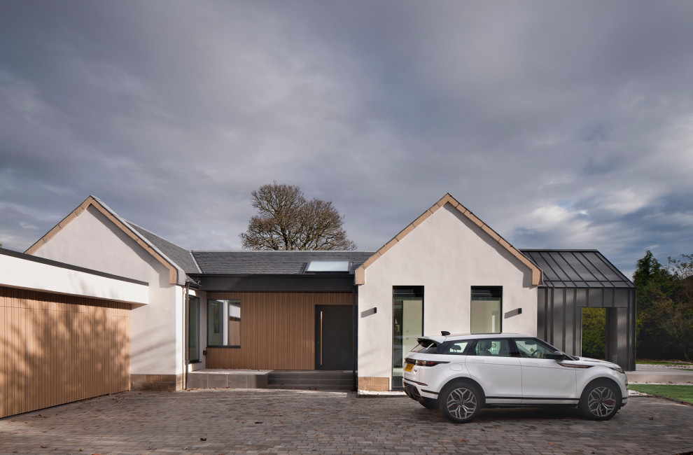This is an example of a large and multi-coloured contemporary bungalow front house exterior in Glasgow with mixed cladding, a pitched roof, a shingle roof and a grey roof.