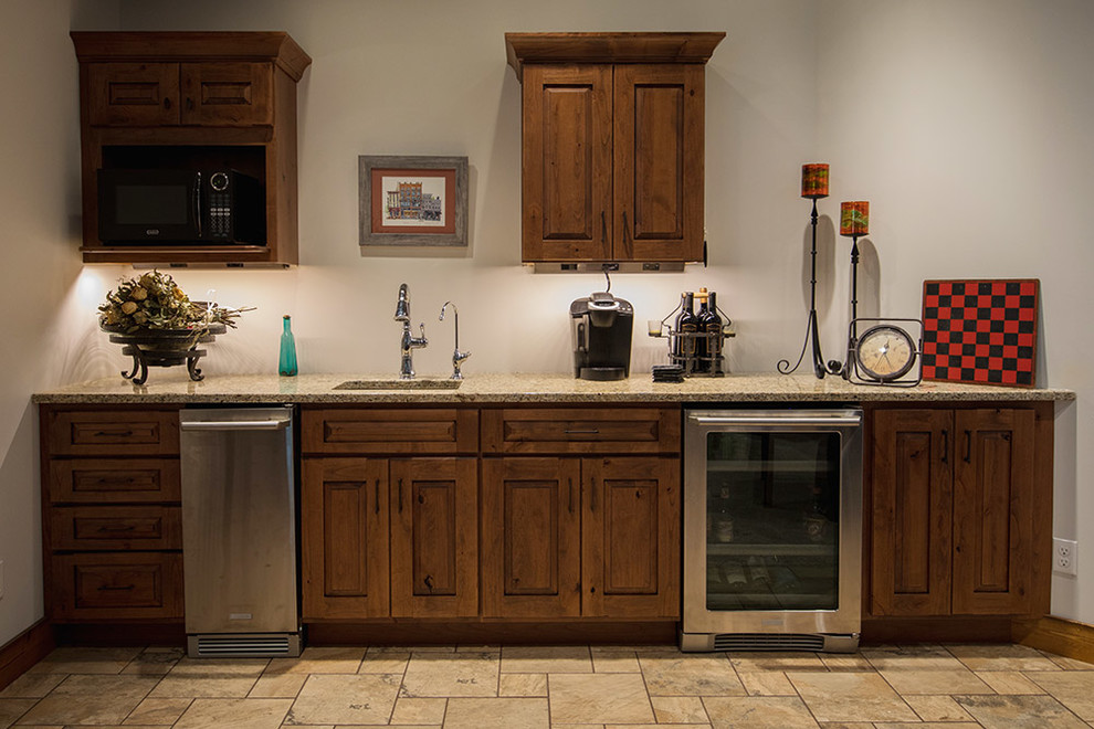Example of a mid-sized mountain style single-wall wet bar design with an undermount sink, raised-panel cabinets and distressed cabinets