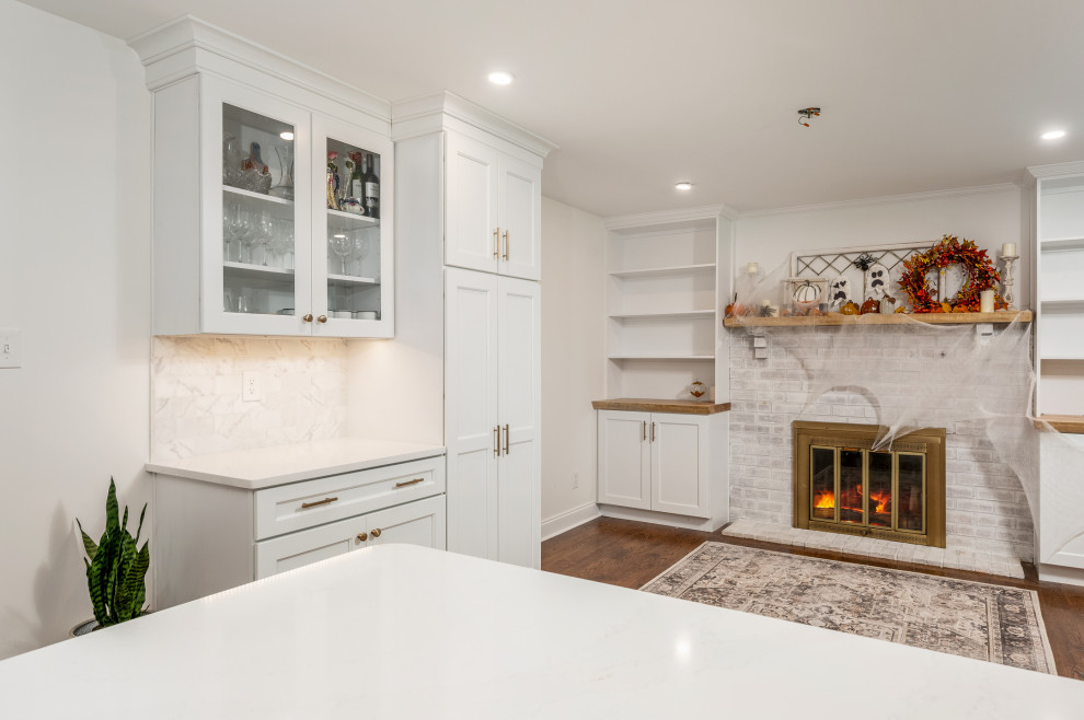 Design ideas for a large classic u-shaped kitchen pantry in Philadelphia with a belfast sink, recessed-panel cabinets, white cabinets, engineered stone countertops, stainless steel appliances and a breakfast bar.