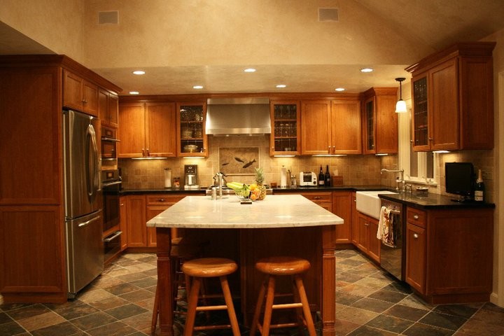 Transitional kitchen photo in Boston with medium tone wood cabinets, beige backsplash, stainless steel appliances and an island