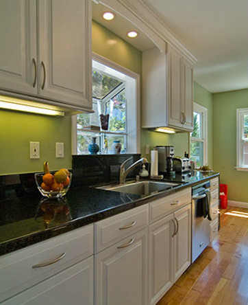 Example of a mid-sized classic galley enclosed kitchen design with a double-bowl sink, shaker cabinets, dark wood cabinets, green backsplash and stainless steel appliances