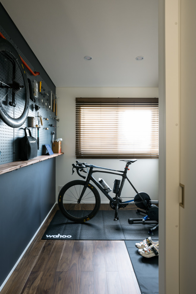 Foto di una stanza da lavoro moderna con pareti nere, parquet scuro, pavimento marrone, soffitto in carta da parati e carta da parati