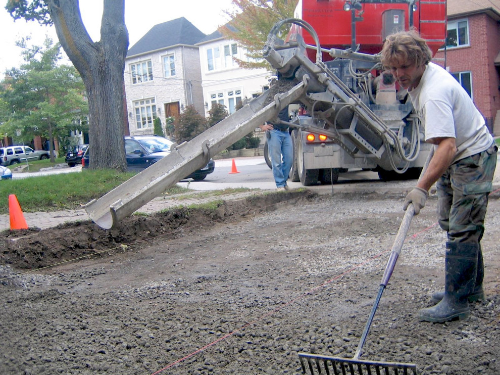 Peter Solti raking cement base in Toronto