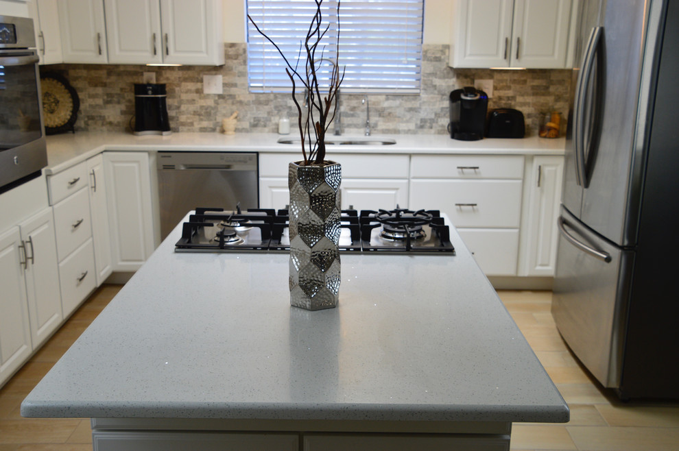 Example of a mid-sized transitional l-shaped porcelain tile enclosed kitchen design in Albuquerque with an undermount sink, raised-panel cabinets, white cabinets, quartz countertops, beige backsplash, porcelain backsplash, stainless steel appliances and no island