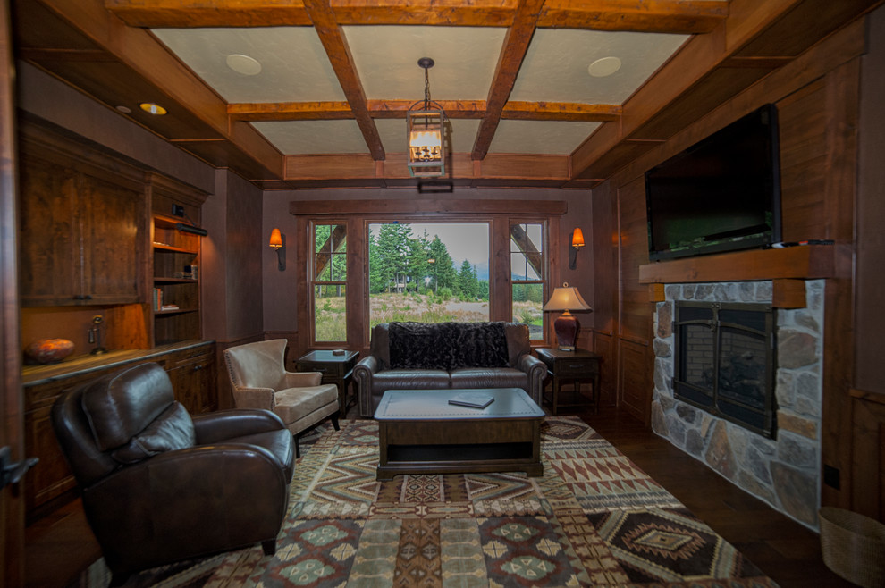 This is an example of a country home office in Seattle with dark hardwood floors, a ribbon fireplace, a stone fireplace surround and a built-in desk.
