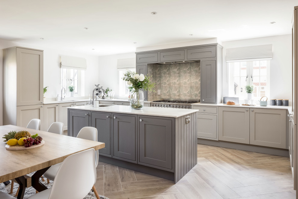 Design ideas for an expansive transitional u-shaped open plan kitchen in Dorset with shaker cabinets, grey cabinets, quartzite benchtops, porcelain floors, with island and white benchtop.