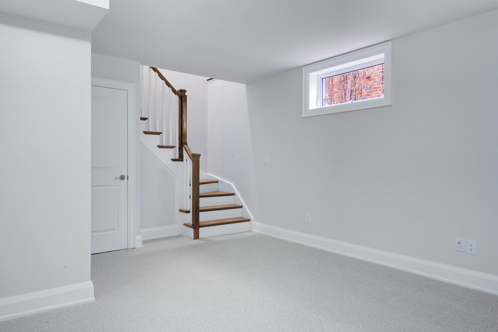 This is an example of a large transitional look-out basement in Toronto with grey walls and carpet.