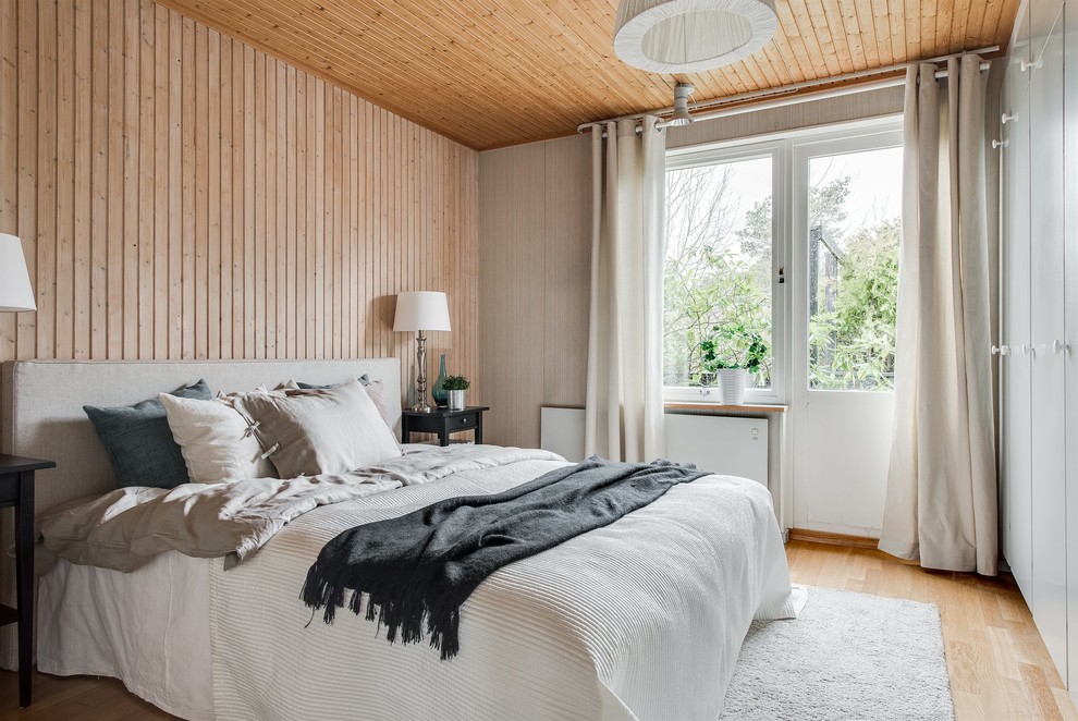 Photo of a mid-sized scandinavian master bedroom in Gothenburg with beige walls, no fireplace, light hardwood floors and beige floor.