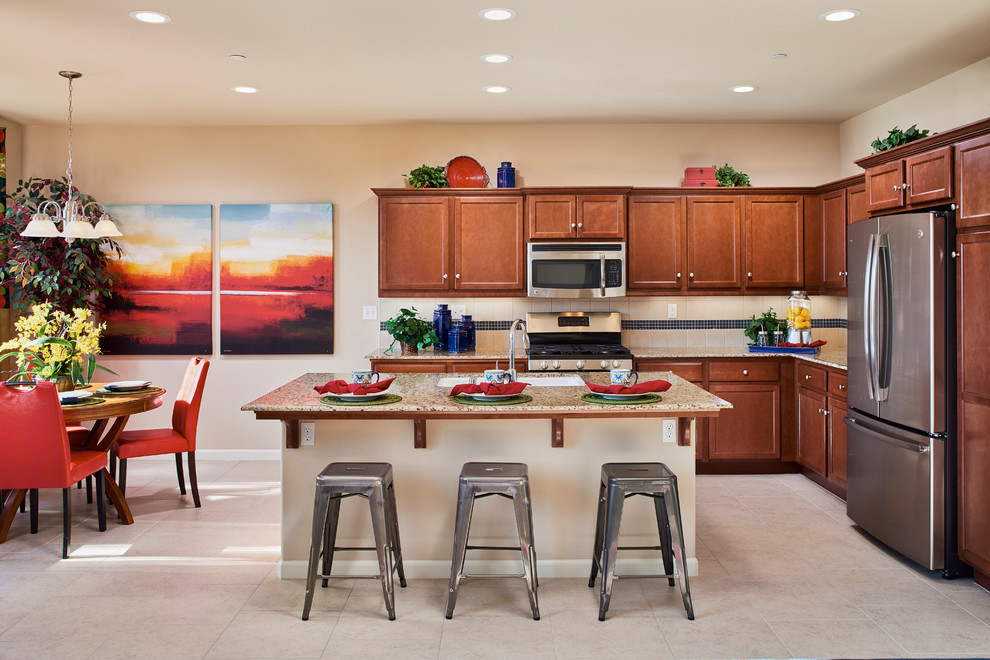 Inspiration for a transitional kitchen remodel with a drop-in sink, brown cabinets, granite countertops, beige backsplash, ceramic backsplash, stainless steel appliances and an island