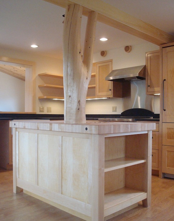 Mid-sized l-shaped medium tone wood floor eat-in kitchen photo with medium tone wood cabinets, solid surface countertops, stainless steel appliances and an island