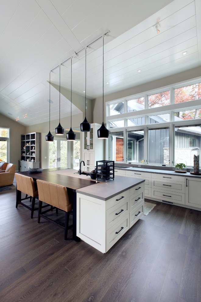 Design ideas for a large transitional l-shaped open plan kitchen in Grand Rapids with an undermount sink, beaded inset cabinets, white cabinets, concrete benchtops, panelled appliances, medium hardwood floors and with island.