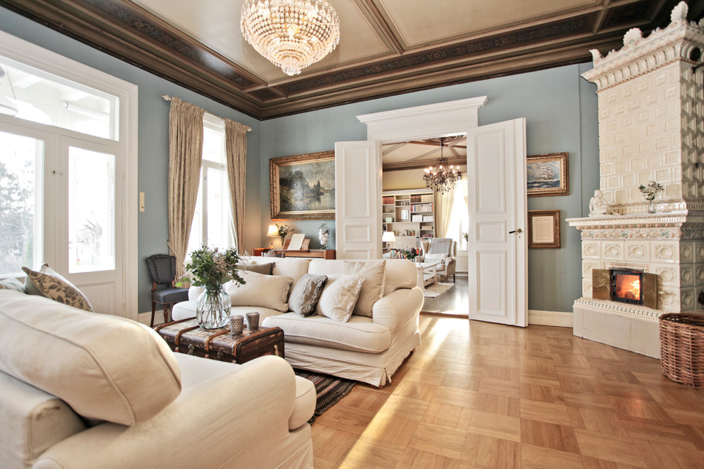 Traditional living room in Other with blue walls, medium hardwood floors and a corner fireplace.
