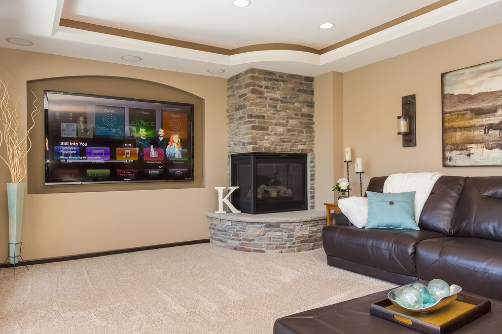 This is an example of a mid-sized traditional look-out basement in Minneapolis with beige walls, carpet, a corner fireplace, a stone fireplace surround and beige floor.