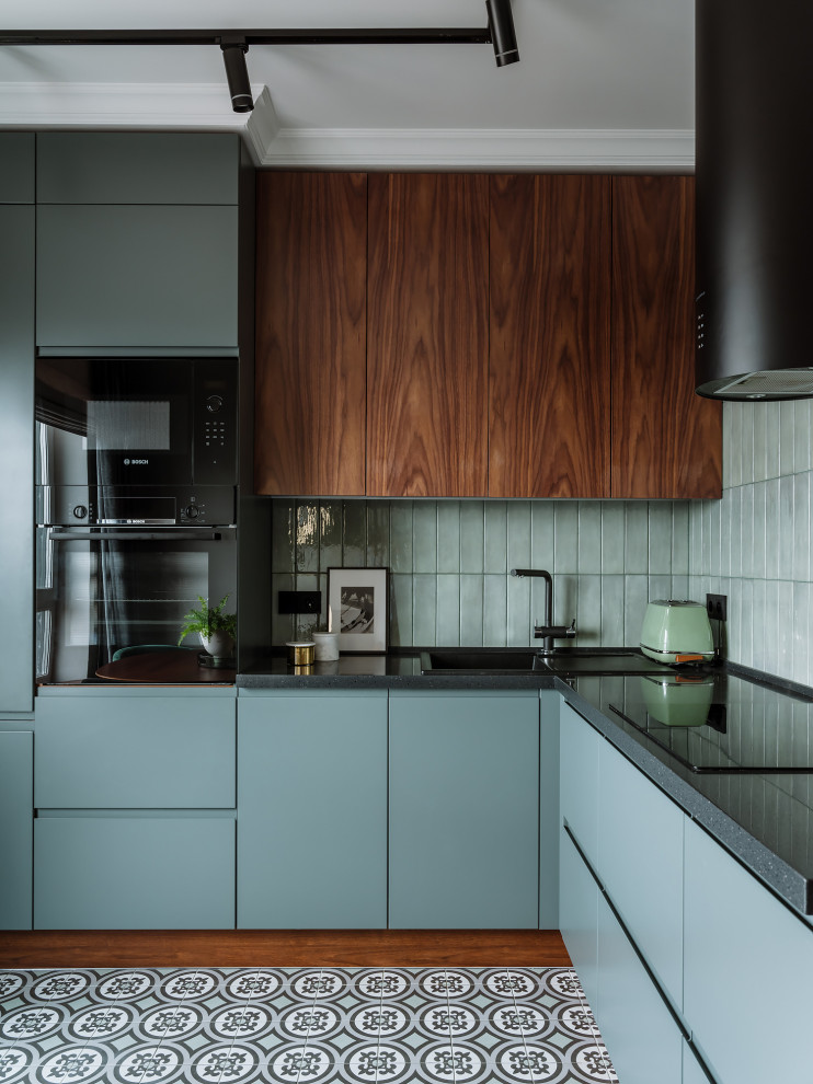 Design ideas for a contemporary l-shaped kitchen in Moscow with a drop-in sink, flat-panel cabinets, grey cabinets, grey splashback, black appliances, no island, grey floor and grey benchtop.