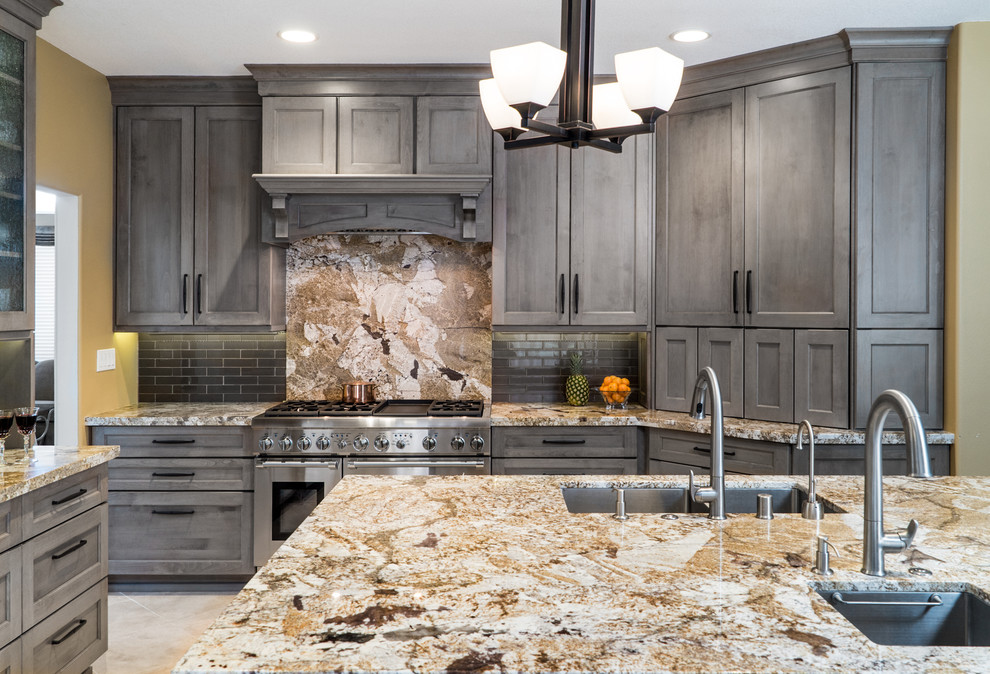 Mid-sized transitional open plan kitchen in Orange County with an undermount sink, shaker cabinets, grey cabinets, granite benchtops, grey splashback, glass tile splashback, stainless steel appliances, porcelain floors and with island.
