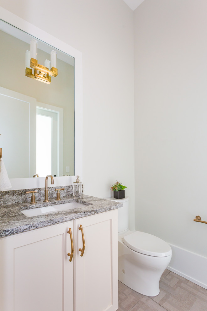 Mid-sized transitional powder room in Orlando with recessed-panel cabinets, white cabinets, a one-piece toilet, white walls, porcelain floors, an undermount sink, engineered quartz benchtops, grey floor, grey benchtops and a built-in vanity.