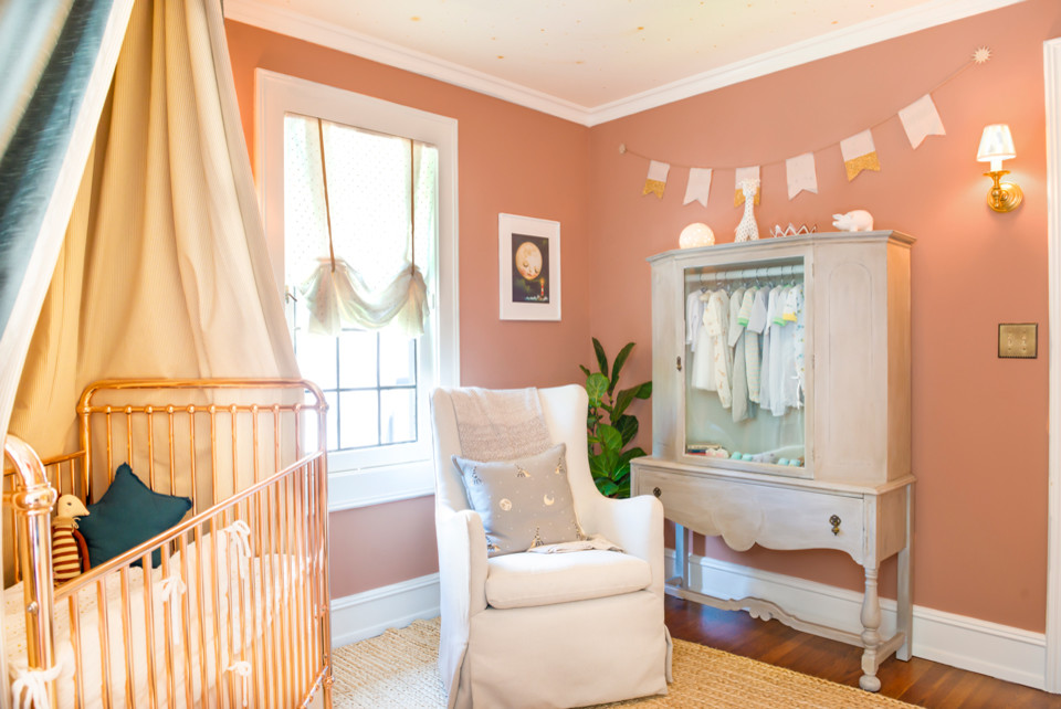 Design ideas for a mid-sized eclectic nursery for girls in Los Angeles with pink walls, carpet and beige floor.