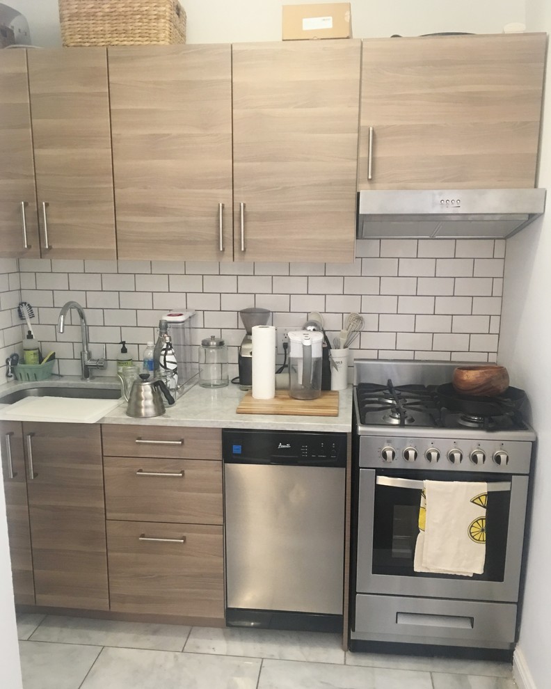 This is an example of a contemporary kitchen in New York with flat-panel cabinets, brown cabinets, granite benchtops, white splashback, ceramic splashback, stainless steel appliances, ceramic floors, grey floor and white benchtop.