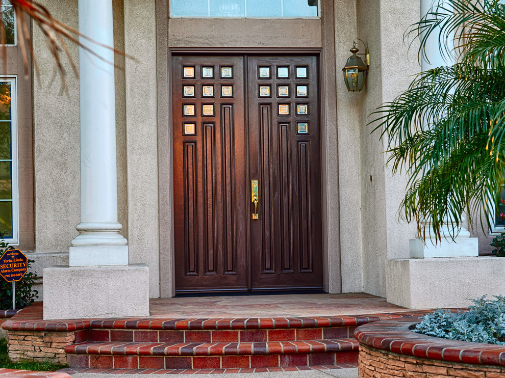 Photo of an expansive contemporary front door in Orange County with beige walls, a double front door and a dark wood front door.