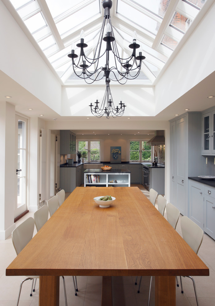 Inspiration for a traditional kitchen/dining combo in London with white walls and limestone floors.