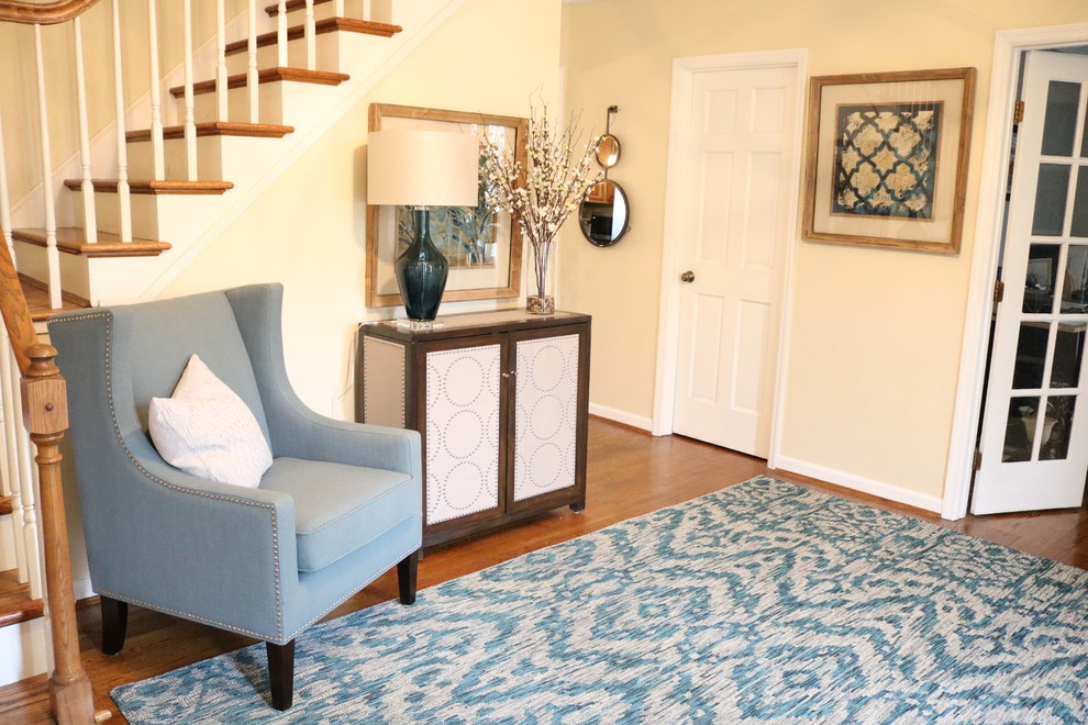 Inspiration for a small transitional medium tone wood floor foyer remodel in Cincinnati with yellow walls
