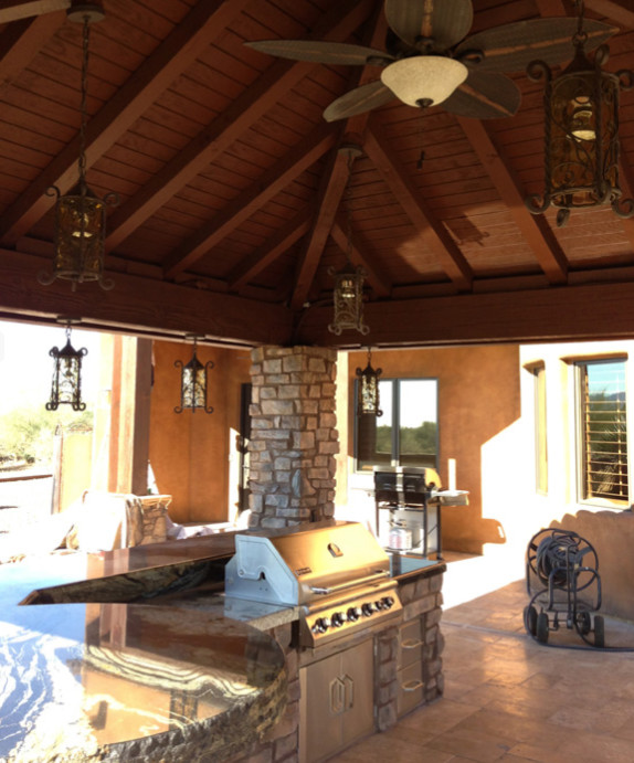 Patio kitchen - mid-sized rustic backyard stone patio kitchen idea in Phoenix with a roof extension