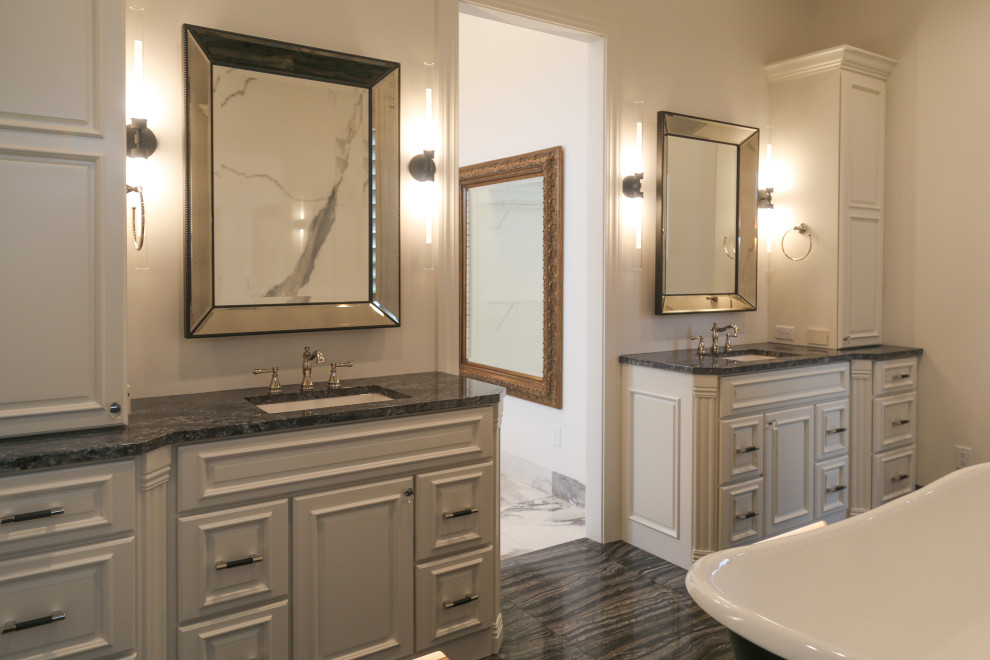 Example of a large transitional master black and white tile and porcelain tile porcelain tile, black floor and double-sink claw-foot bathtub design with raised-panel cabinets, white cabinets, a two-piece toilet, white walls, an undermount sink, granite countertops, black countertops and a built-in vanity