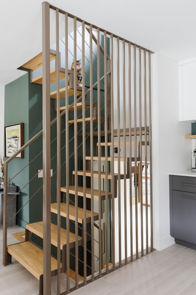 Aménagement d'un escalier contemporain en U de taille moyenne avec des marches en métal, des contremarches en bois et un garde-corps en métal.