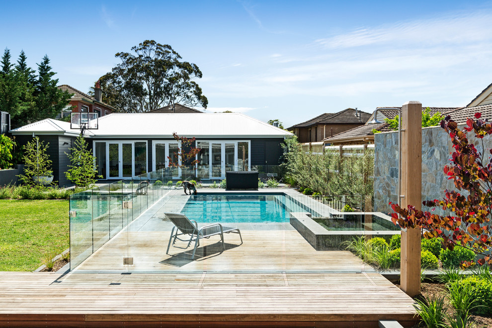 This is an example of a transitional backyard rectangular pool in Melbourne with decking.