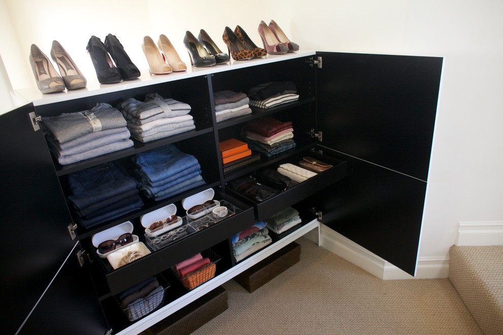 This is an example of a small contemporary women's dressing room in Los Angeles with white cabinets and carpet.