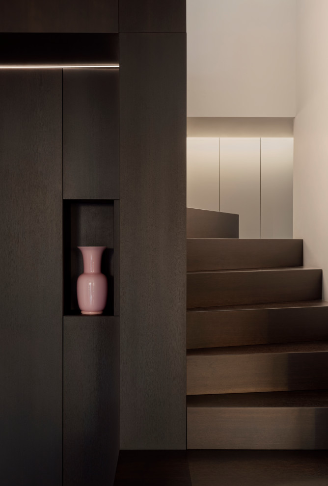 Mid-sized painted wood u-shaped staircase in Milan with painted wood risers, glass railing and panelled walls.
