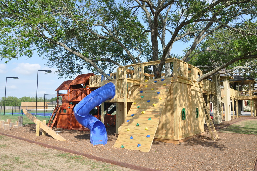This is an example of an expansive traditional garden in New Orleans with with outdoor playset.