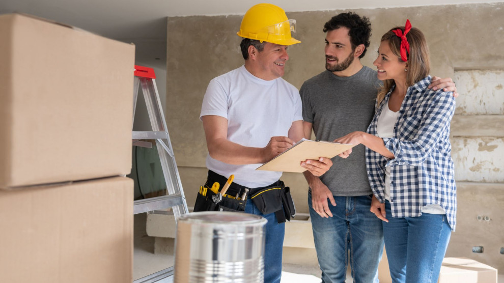 A couple discussing remodeling plans with a contractor, representing a stress-free home renovation experience.