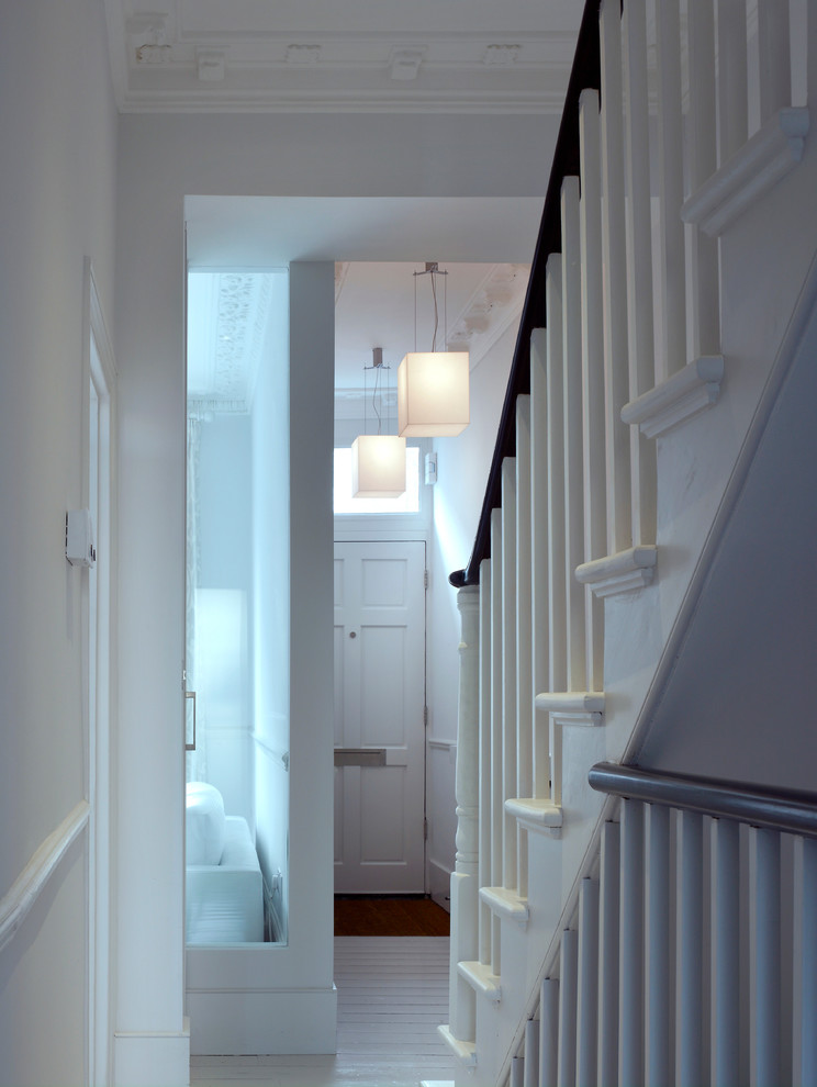 Design ideas for a mid-sized transitional hallway in London with white walls and painted wood floors.