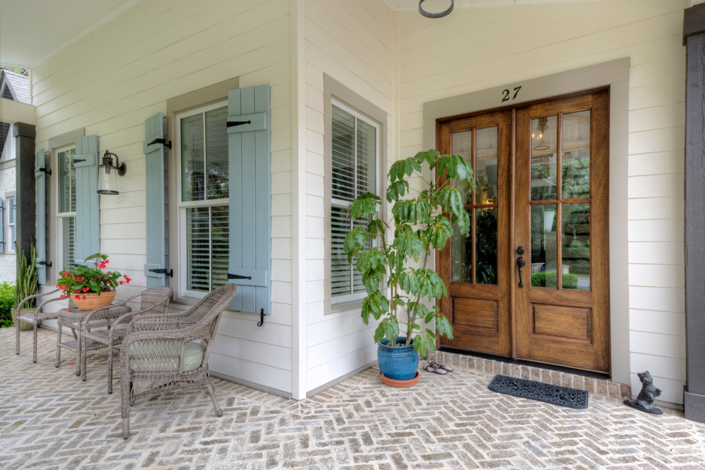This is an example of a mid-sized country front yard verandah in Jacksonville with brick pavers and a roof extension.