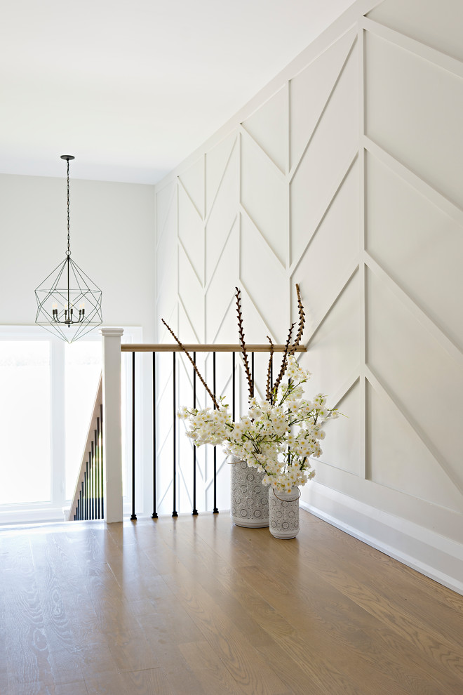 Photo of a country hallway in Toronto with white walls and light hardwood floors.