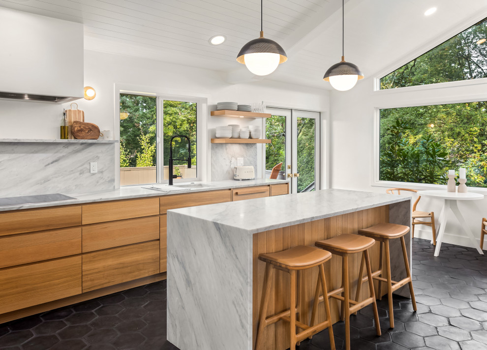 Photo of a midcentury kitchen in Portland with flat-panel cabinets, light wood cabinets, marble benchtops, marble splashback, terra-cotta floors, with island, black floor and vaulted.