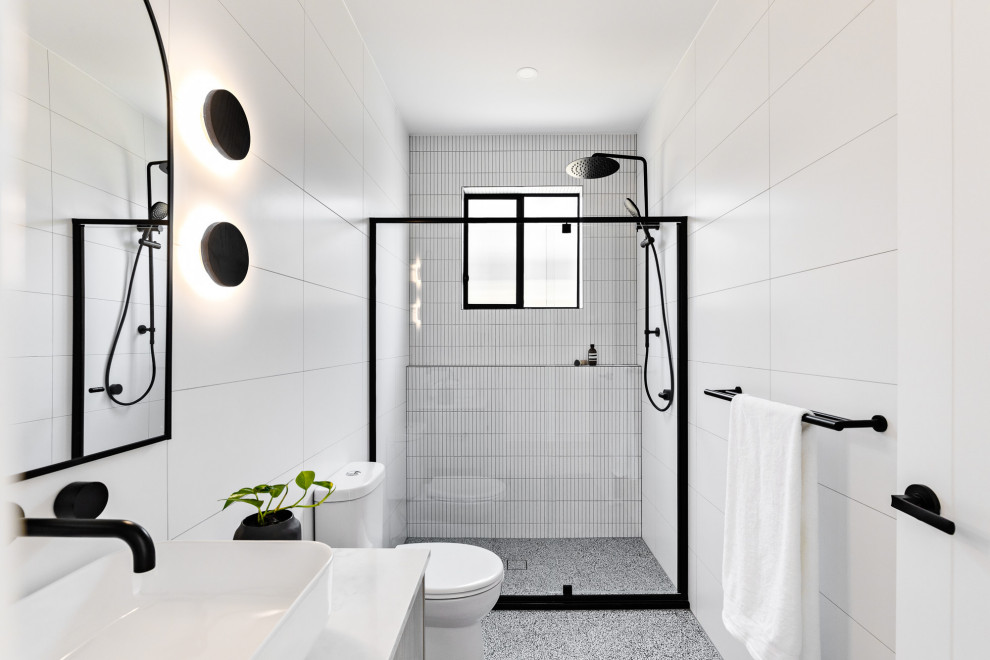 Ispirazione per una stretta e lunga stanza da bagno minimal con piastrelle grigie, pavimento in gres porcellanato, top in quarzo composito e pavimento grigio