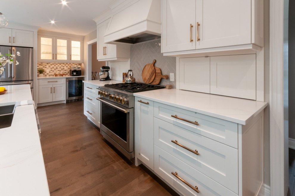 Inspiration for a large transitional galley medium tone wood floor and brown floor eat-in kitchen remodel in Toronto with an undermount sink, recessed-panel cabinets, blue cabinets, quartz countertops, gray backsplash, porcelain backsplash, stainless steel appliances, an island and white countertops