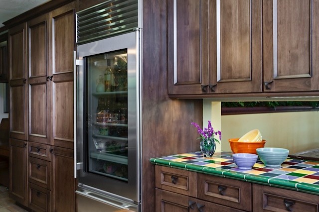 Inspiration for a large traditional u-shaped open plan kitchen in San Francisco with dark wood cabinets, tile benchtops, green splashback, ceramic splashback, stainless steel appliances and ceramic floors.