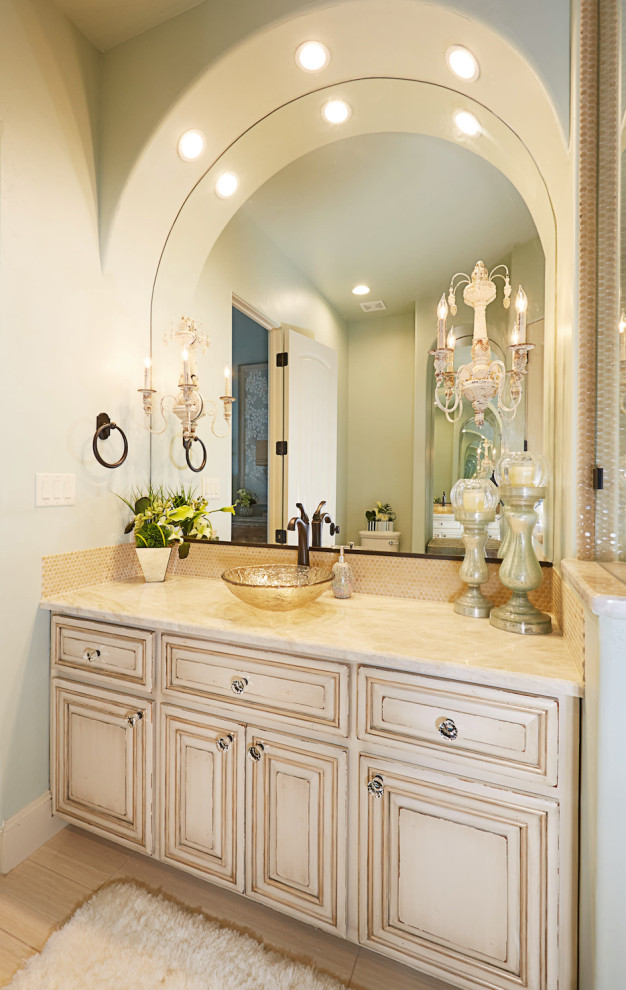 Design ideas for a mediterranean master bathroom in Dallas with raised-panel cabinets, a freestanding tub, an open shower, a one-piece toilet, beige tile, limestone, green walls, limestone floors, an undermount sink, onyx benchtops, beige floor, an open shower and yellow benchtops.