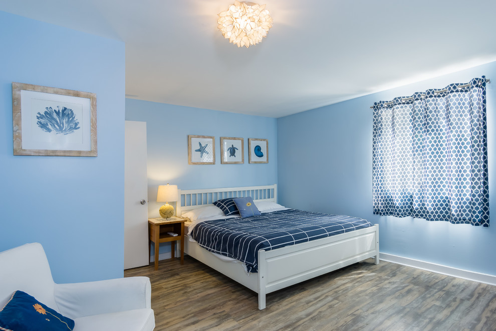 Design ideas for a mid-sized beach style guest bedroom in Los Angeles with blue walls, linoleum floors and brown floor.
